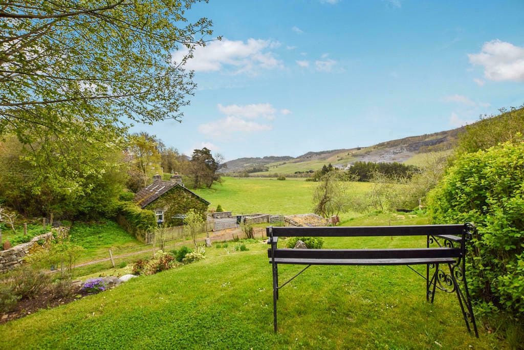 Hawthorn Brae - side garden with bench with overview of surrounding fields.
