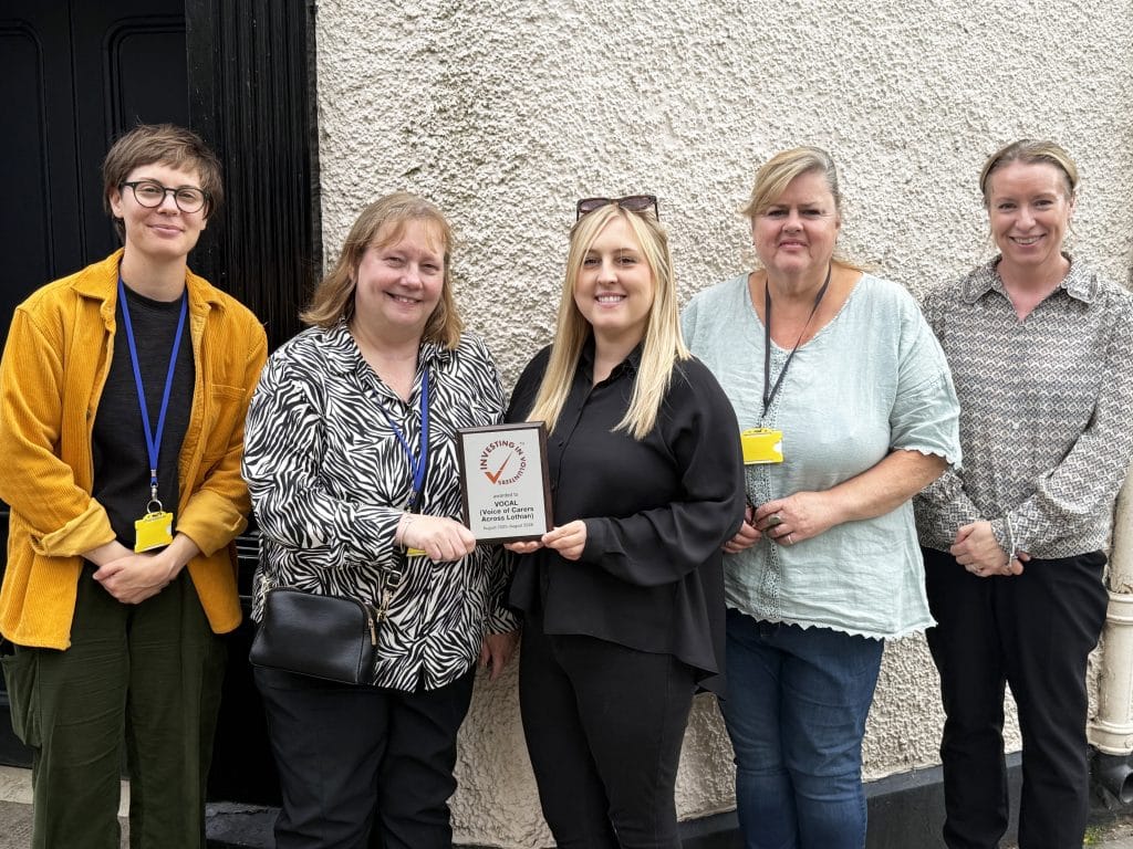 VOCAL staff holding the Investing in Volunteers plaque.